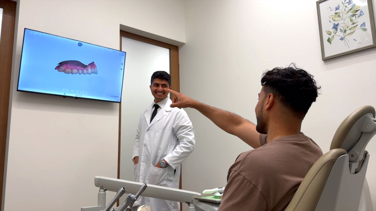 Dentist at Smile Circle Dental discussing 3D teeth scan with a patient in a modern exam room