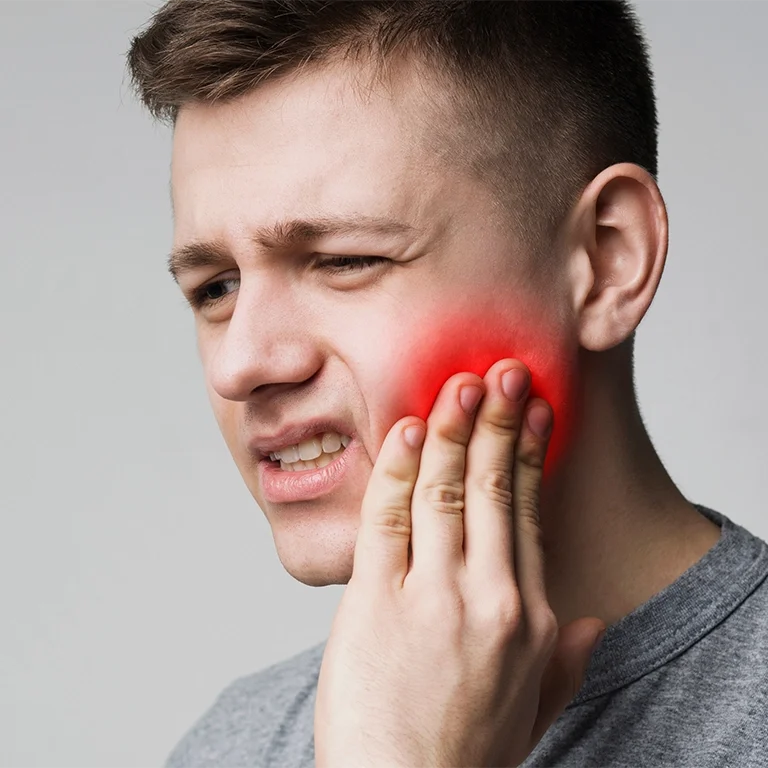 Frustrated young man touching his tooth and frowning face